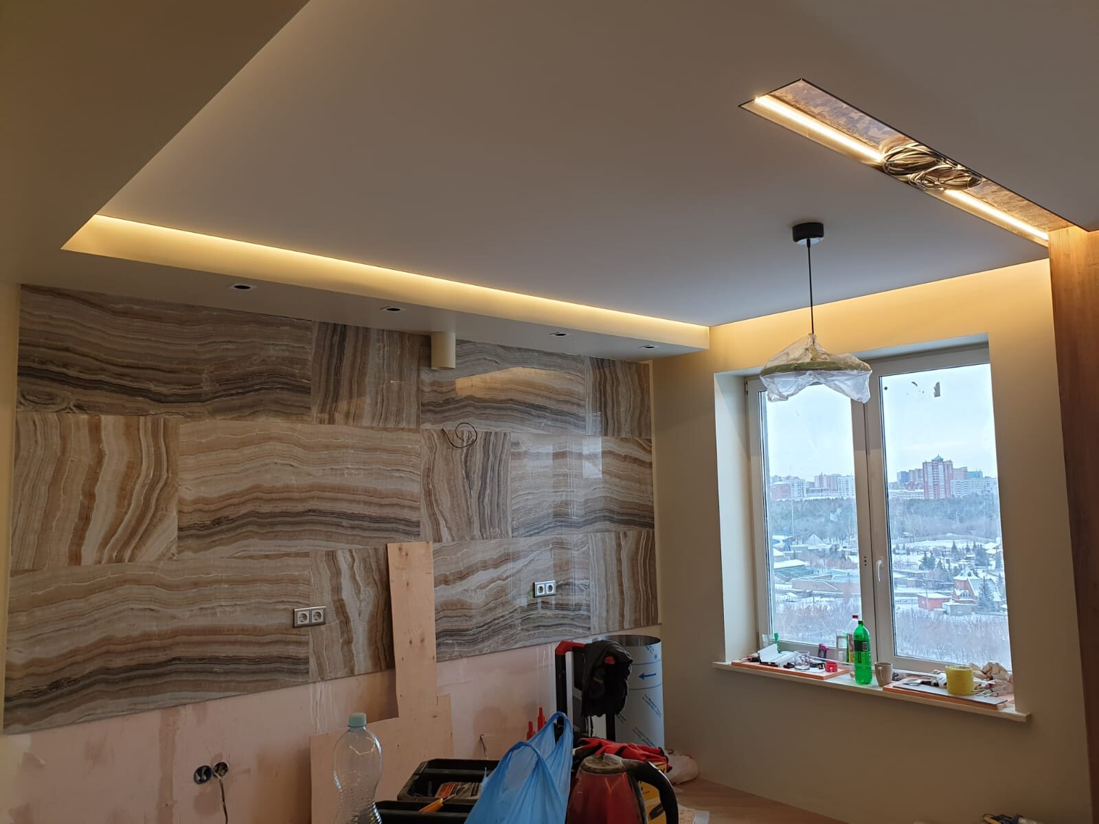 Stone wall finish and warm recessed ceiling lighting