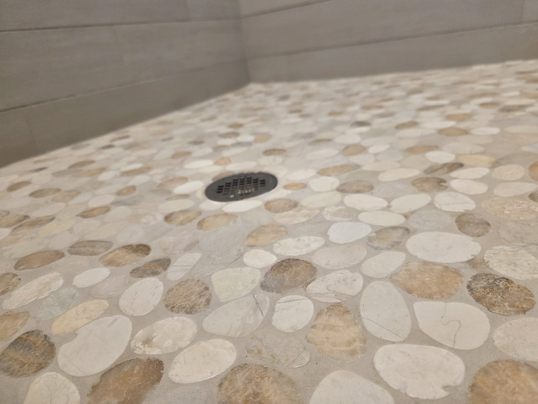 Close detail of a river-stone shower drain