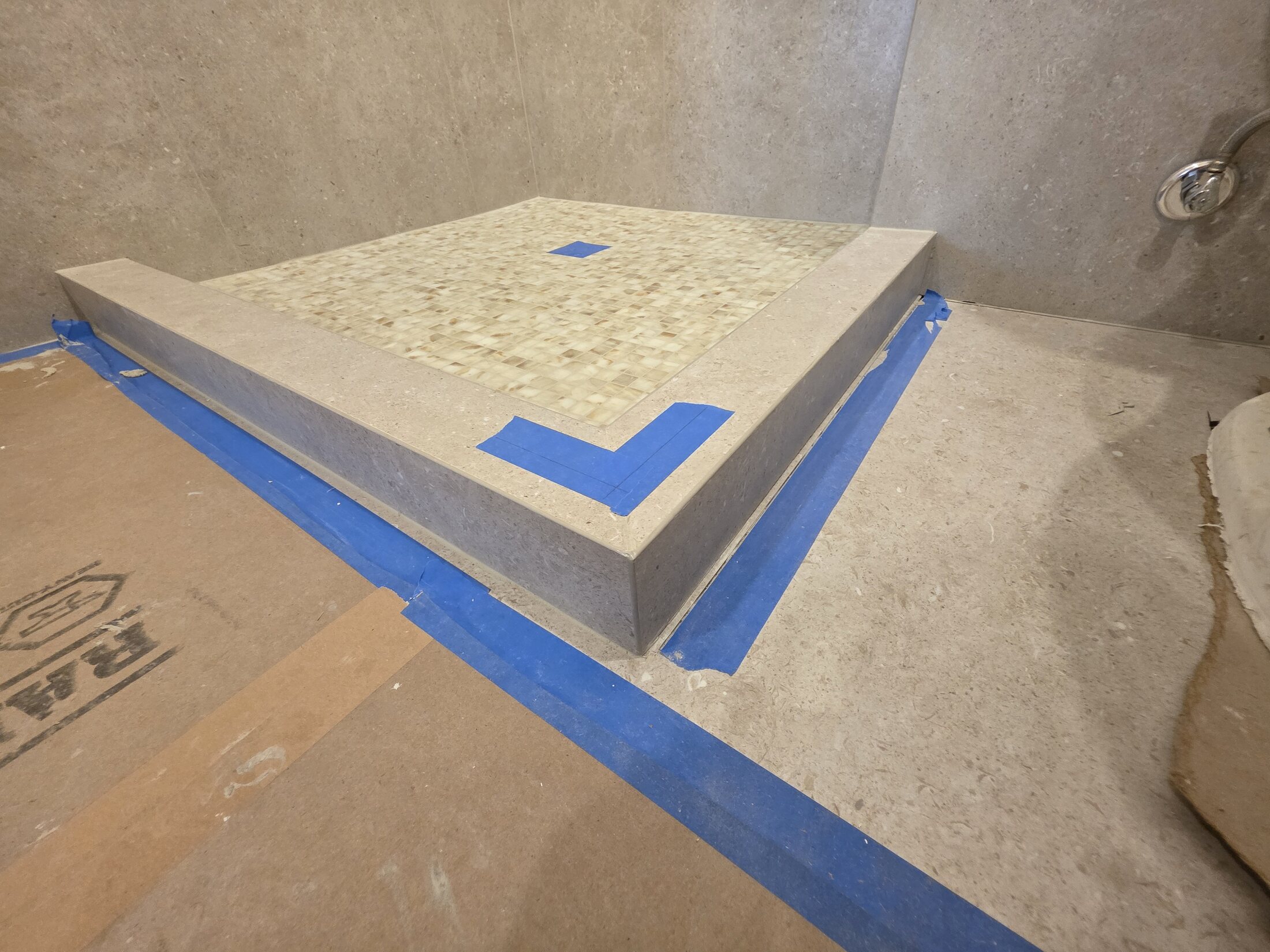 Mosaic shower bench with carefully set transition lines